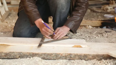 Carpenter marking with set square on wooden plank Stock Footage 88334643