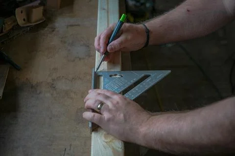 Carpenter marking timber with speed square and pencil Foto stock