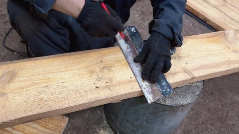 Carpenter marking wooden plank with pencil and square 스톡 동영상 335290053