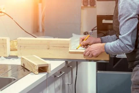The carpenter marks the dimensions on the board for further cutting, close-.. Stock Photos