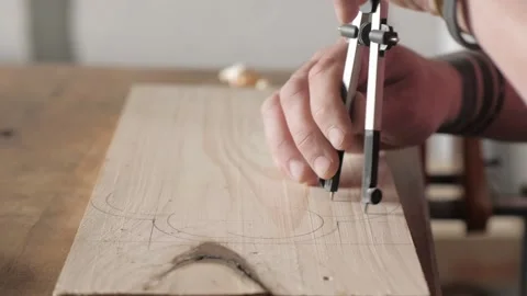 A carpenter marks a pine wooden plank with a compass. marking carpentry tools Stock Footage 156670375