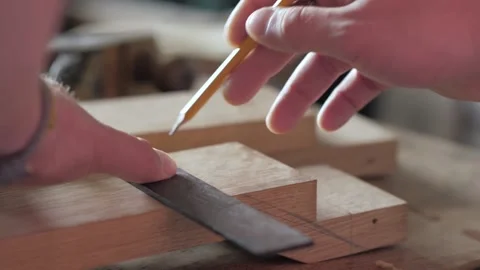 A carpenter marks a wooden board with a try Square. Make a mark with a pencil Stock Footage 156690699