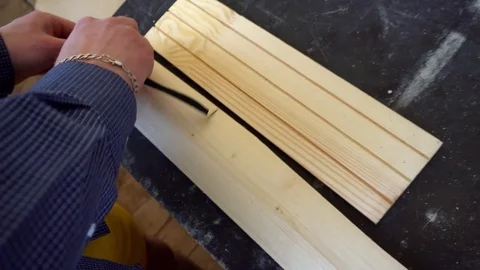 The carpenter measures a piece of Board Stock Footage 74751956