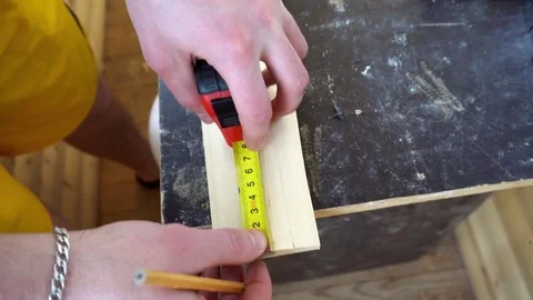 The carpenter measures a piece of Board Stock Footage 74753314