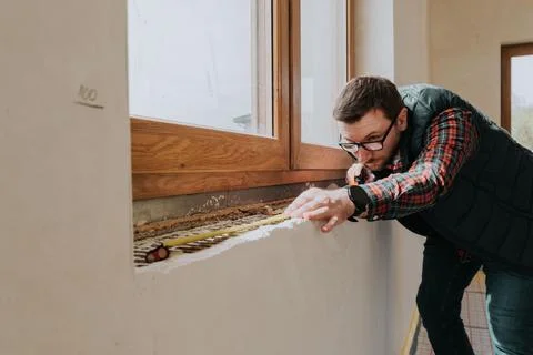 Carpenter measuring window ledge in new house Stock Photos