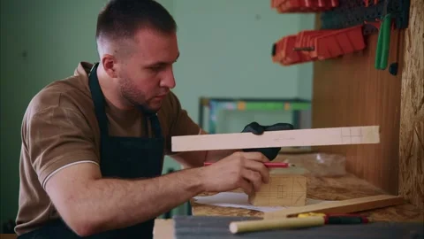 Carpenter measuring wooden plank in workshop Stock Footage 308932917