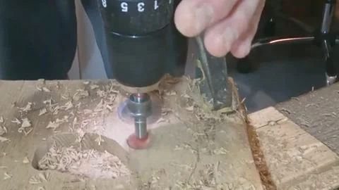 A carpenter milling a wooden workpiece in the workshop, wood chips flying Stock Footage 302102167