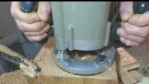 A carpenter milling a wooden workpiece in the workshop, wood chips flying Stock Footage 302102192