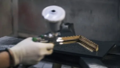Carpenter is painting a tamplate of a frame using black paint. Stock Footage 72256973