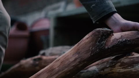 Carpenter picks up log to start carving medium slow motion Stock Footage 271195679