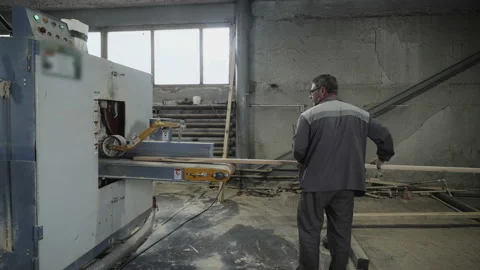 A Carpenter is placing the timber boards into the modern processing machinery Stock Footage 171529877
