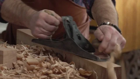 Carpenter Planes Solid Wood in his Workshop Stock Footage 75141734