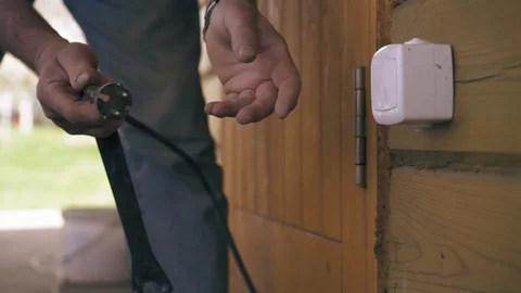 A carpenter is plugging in a power cord of grinder. Man is using an electric saw Stock Footage 90136274