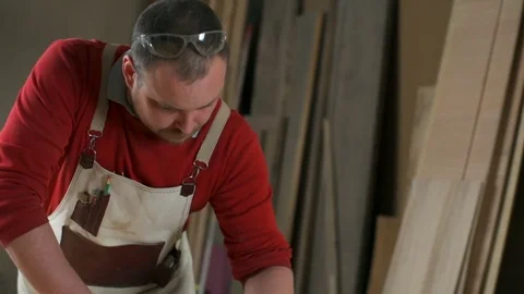Carpenter polishes the edge of the table with abrasive block in workshop closeup Video stock 74493636