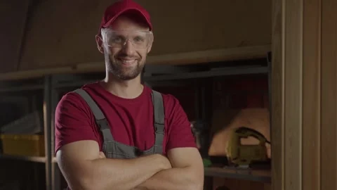 A carpenter prepares for work by putting on protective eyewear in a well-lit Stock Footage 281673407