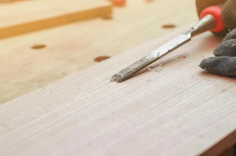 Carpenter processes board with metal chisel Stockfoto's