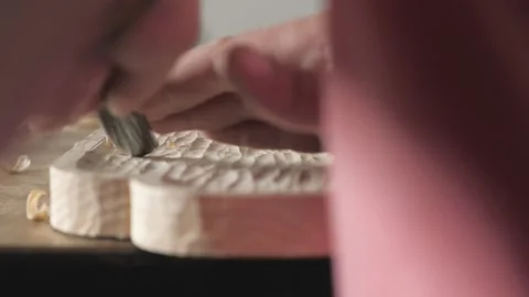 A carpenter processes a pine wood board with a chisel. artisan makes a tea tray Stock Footage 156670651