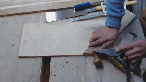 A carpenter processes a wooden blank at an angle with a planer. a woodworker Stock Footage 116782719