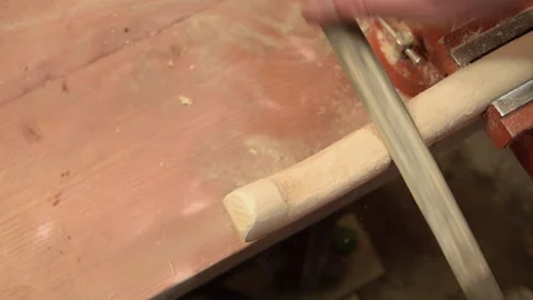 A carpenter processes a wooden handle with a file. Stock Footage 156340546