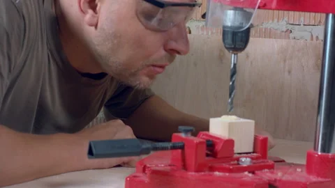 Carpenter in protective glasses blows off sawdust Stock Footage 162923924