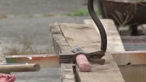 Carpenter pulling a nail from a plank using wrecking bar. Video stock 244238058