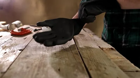 Carpenter puts on gloves in the workshop. close-up. side view. Stock Footage 245983351