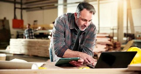 Carpenter, research and man with tech in workshop, online and searching for Stock Photos