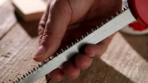 The carpenter runs his finger along the saw blade. close up shot. Stock Footage 246366998