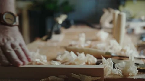 The carpenter runs his hand over a piece of wood. The carpenter checks the Stock Footage 156500161