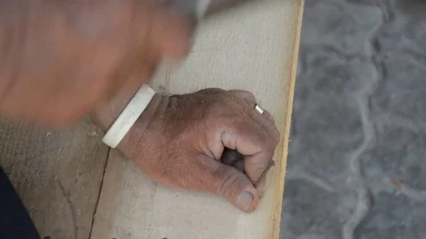 Carpenter' s hands hitting a nail on the head with old and used wood Vídeos de archivo 83792320