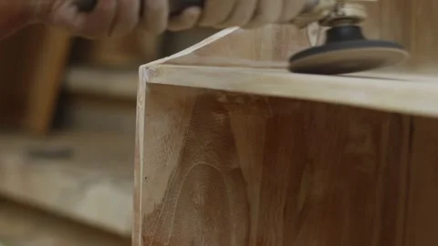 A carpenter sands a board in the workshop, chest of drawers with his own hands Stockbeeldmateriaal 257404738