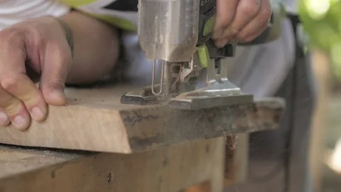 Carpenter sawing an old walnut board with an electric jigsaw Stock Footage 137149969