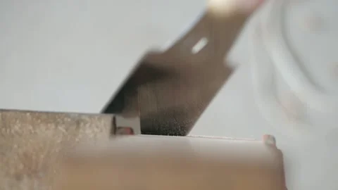 Carpenter sawing a piece from a oak board using a hand saw for wood Stock Footage 156690729