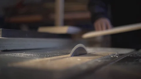 The carpenter saws the boards on a circular saw. Carpentry workshop Video stock 107612506