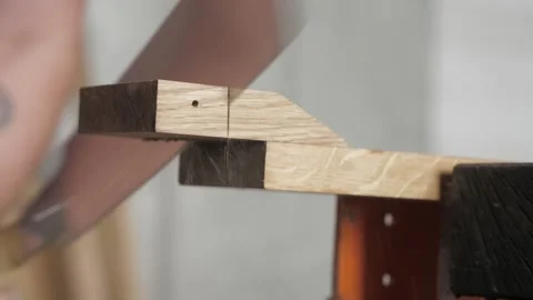 Carpenter saws a piece from a oak board with a hand saw. carpenter sawing Stock Footage 156690710