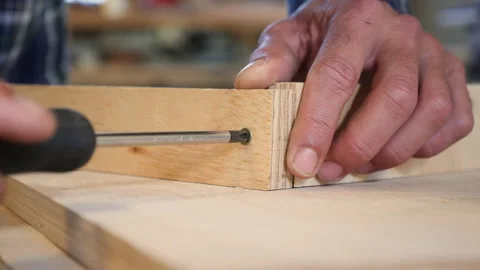 Carpenter screws in screw with screw driver 스톡 동영상 135309605