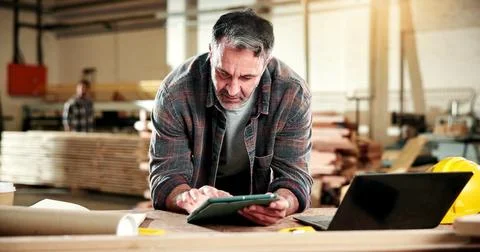 Carpenter, scroll and man with tablet in workshop, online and searching for Stock Photos