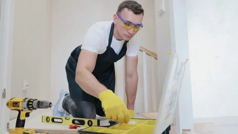 The carpenter searching a necessary screw into box of screws Stock Footage 133359044