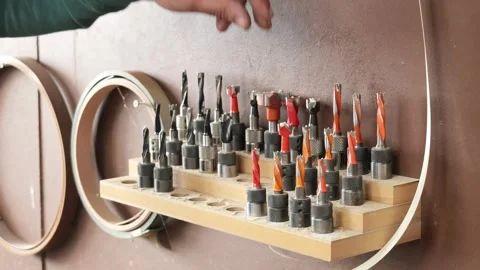 Carpenter selecting drill bit from workshop tool rack 库存影片 335462656