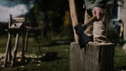 Carpenter sets axe into chopping block to move to shave horse, slow motion Stock Footage 271191337