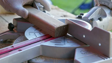 Carpenter sets mitre saw angle 30 degrees and cuts wooden workpiece diagonally Video stock 135744405