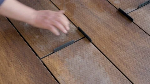Carpenter sets spacing of deck boards on floor wood panel. Flooring installation Stock Footage 155659745