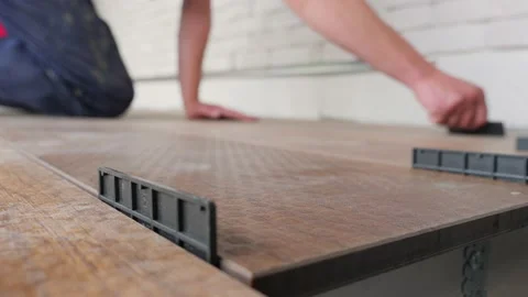 Carpenter sets spacing of deck boards on floor wood panel. Flooring installation Stock Footage 156667000