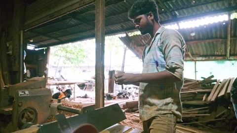 Carpenter shapes wooden block using power tool Stock Footage 313666872