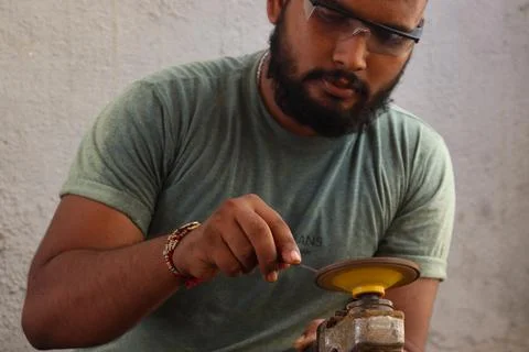 A Carpenter sharp his equipment with machine Stock Photos