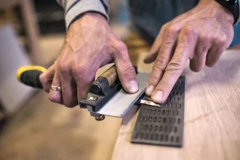 Carpenter sharpening a chisel close up view Stock Photos
