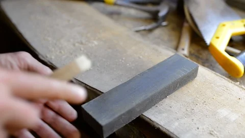 Carpenter sharpening a chisel in a small workshop Stock Footage 111797628
