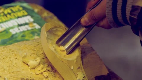 Carpenter Shows Apprentice How to Carve a Wooden Spoon Stock Footage 257973040