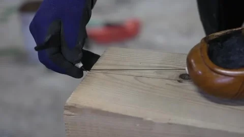 Carpenter snapping an inked marking line across a timber board using a Stock Footage 341595816