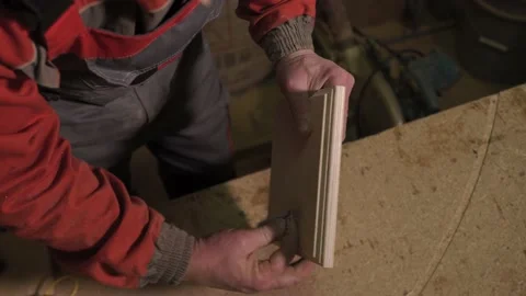 Carpenter stands behind the workplace, polishes with sandpaper, processes wood Stock Footage 149123016